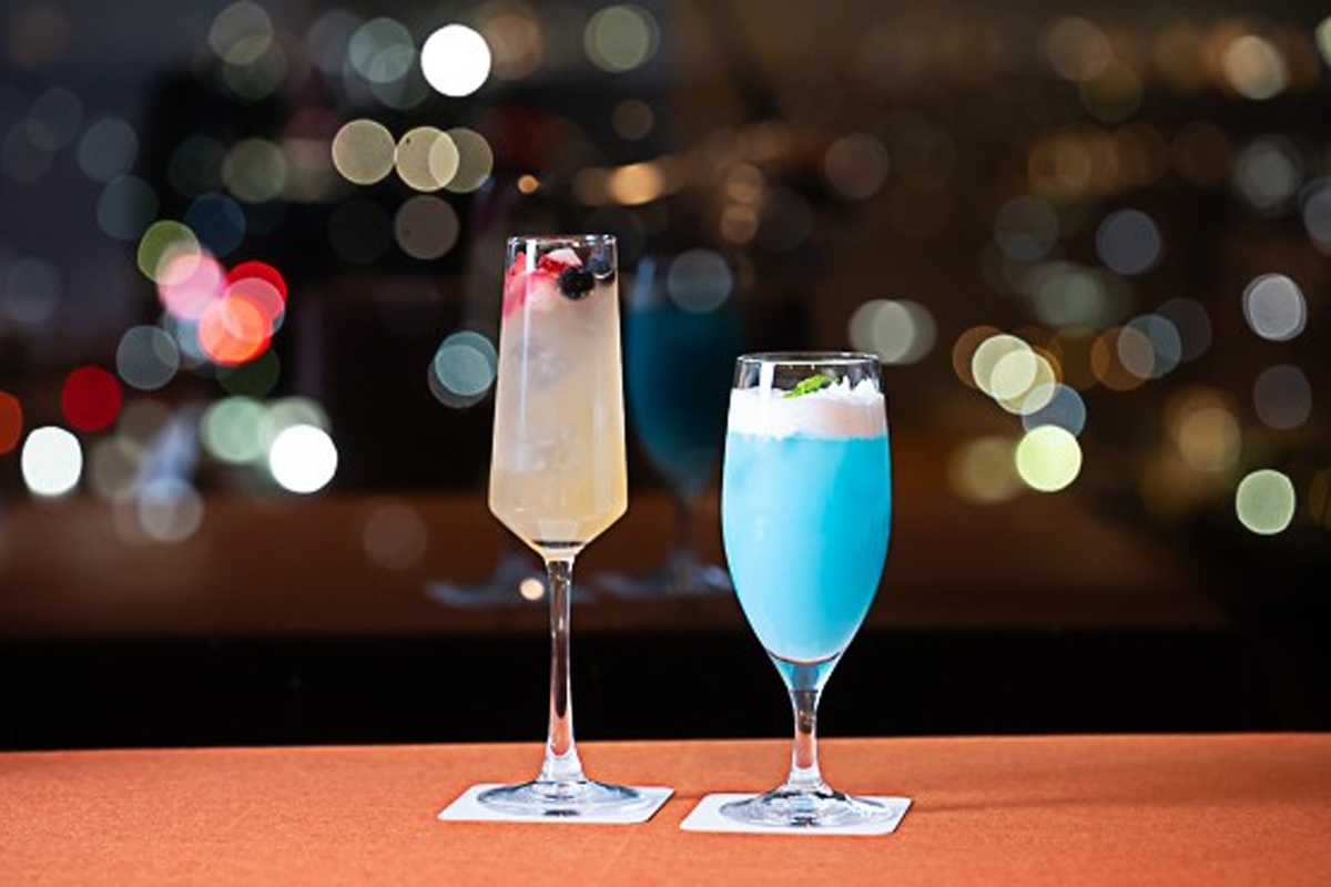 煌めく夜景をバックに楽しむ、彩り豊かなカクテルとモクテル